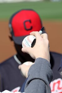Image of hands holding out baseballs for Cleveland Indians players to sign, before a spring training game in 2017